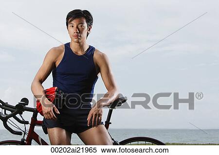 Man resting on bike along ocean, looking at camera View Large Photo Image Stock Photography - Man resting on bike along ocean, looking at camera. Fotosearch