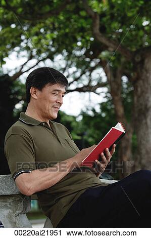 Man sitting on bench in park reading View Large Photo Image Stock Image - Man sitting on bench in park reading. Fotosearch