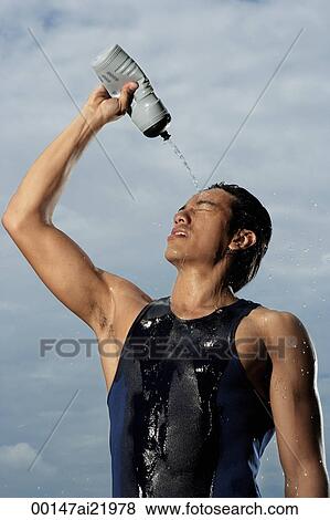 Man squeezing water bottle over face, cooling off after workout View Large Photo Image Stock Photo - Man squeezing water bottle over face, cooling off after workout. Fotosearch