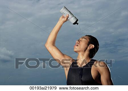Man squeezing water bottle over face, cooling off after workout, hot View Large Photo Image Stock Photo - Man squeezing water bottle over face, cooling off after workout, hot. Fotosearch