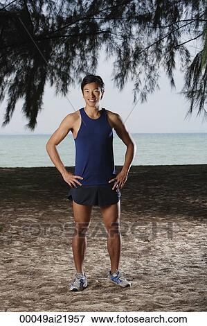 Man standing by beach after running, workout View Large Photo Image Stock Photo - Man standing by beach after running, workout. Fotosearch