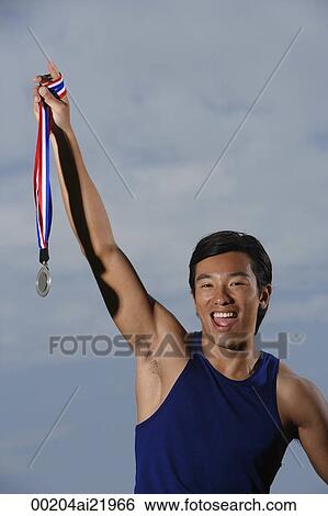 Man winning race, holding medal, smiling View Large Photo Image Stock Photograph - Man winning race, holding medal, smiling. Fotosearch