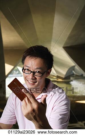 Stock Photograph - Man with credit card smiling at camera. Fotosearch