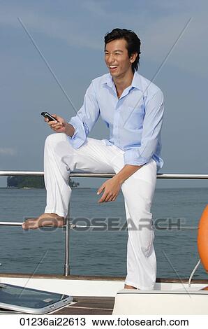 Man with mobile phone on yacht View Large Photo Image Stock Image - Man with mobile phone on yacht. Fotosearch