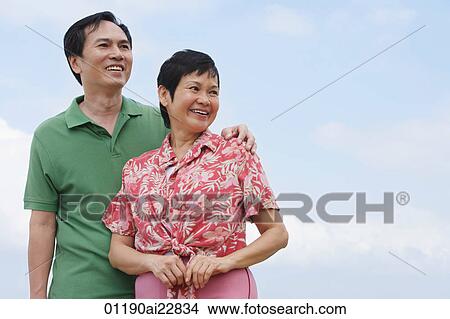 Mature couple at the beach looking into distance View Large Photo Image Picture - Mature couple at the beach looking into distance. Fotosearch