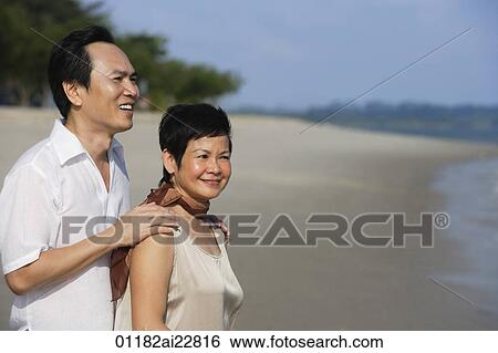 Mature couple at the beach, looking into distance View Large Photo Image Stock Photograph - Mature couple at the beach, looking into distance. Fotosearch
