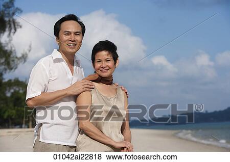 Mature couple at the beach smiling at camera View Large Photo Image Stock Photo - Mature couple at the beach smiling at camera. Fotosearch