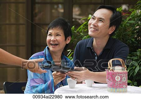 Mature couple being handed menu in restaurant View Large Photo Image Stock Image - Mature couple being handed menu in restaurant. Fotosearch