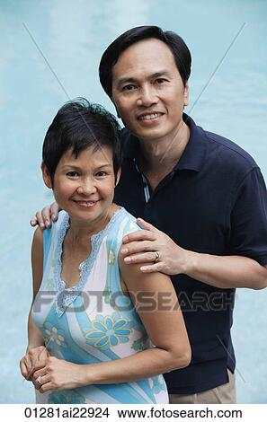Mature couple by the pool smiling at camera View Large Photo Image Picture - Mature couple by the pool smiling at camera. Fotosearch