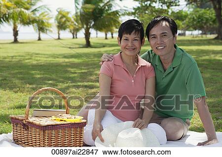 Mature couple having a picnic in the park, smiling at camera View Large Photo Image Stock Photo - Mature couple having a picnic in the park, smiling at camera. Fotosearch