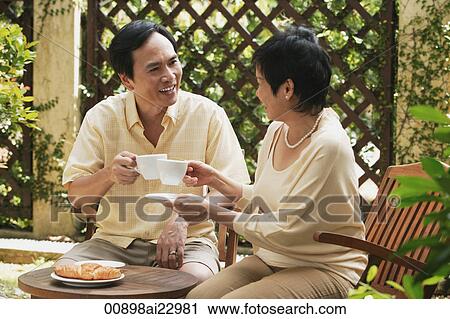 Mature couple having tea in the garden View Large Photo Image Stock Image - Mature couple having tea in the garden. Fotosearch