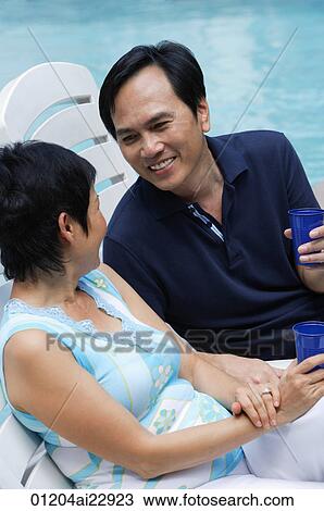 Mature couple in deck chairs by the pool View Large Photo Image Stock Image - Mature couple in deck chairs by the pool. Fotosearch