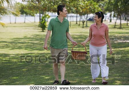 Mature couple in the park going for a picnic View Large Photo Image Stock Photo - Mature couple in the park going for a picnic. Fotosearch