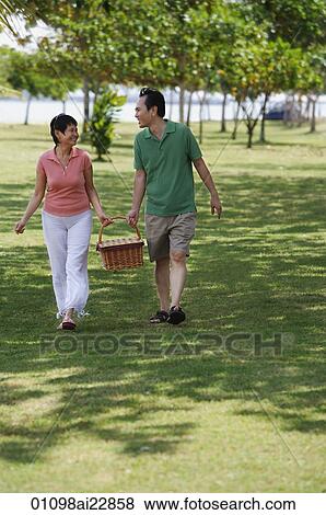Mature couple in the park going for a picnic View Large Photo Image Stock Photo - Mature couple in the park going for a picnic. Fotosearch