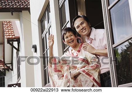 Mature couple smiling and waving at camera View Large Photo Image Stock Image - Mature couple smiling and waving at camera. Fotosearch