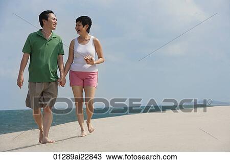 Mature couple walking at the beach View Large Photo Image Stock Image - Mature couple walking at the beach. Fotosearch