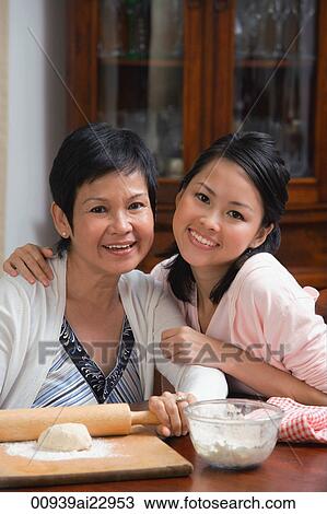 Mother and daughter baking together View Large Photo Image Stock Image - Mother and daughter baking together. Fotosearch