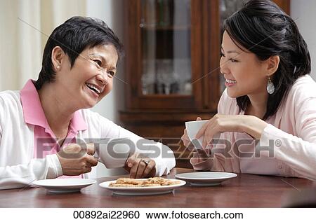 Mother and daughter enjoying tea together View Large Photo Image Stock Image - Mother and daughter enjoying tea together. Fotosearch