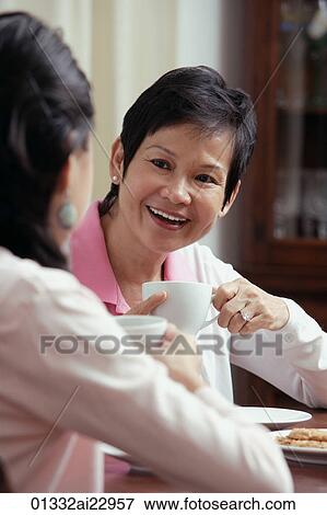Stock Photo - Mother and daughter enjoying tea together. Fotosearch