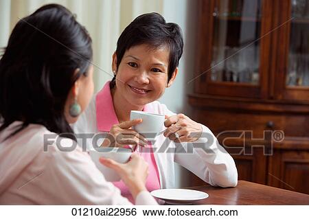 Stock Photograph - Mother and daughter enjoying tea together. Fotosearch