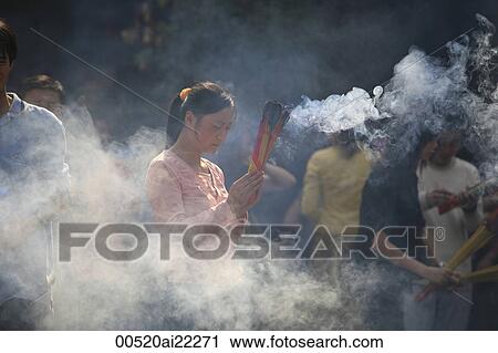 Stock Image - People worshipping at temple, Yuyuan, Shanghai, China. Fotosearch