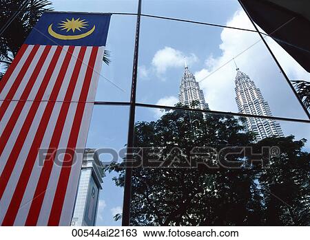 Stock Image - Petronas Towers reflected on the curtain wall of a commercial building, Kuala Lumpur, Malaysia. Fotosearch