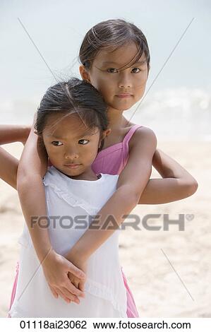 Sisters hugging at the beach View Large Photo Image Stock Image - Sisters hugging at the beach. Fotosearch