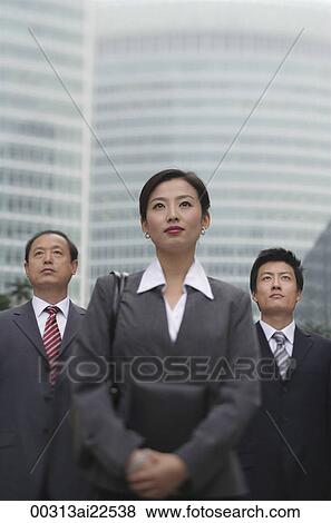 Stock Photo - Three business professionals stand in front of a skyscraper. Fotosearch