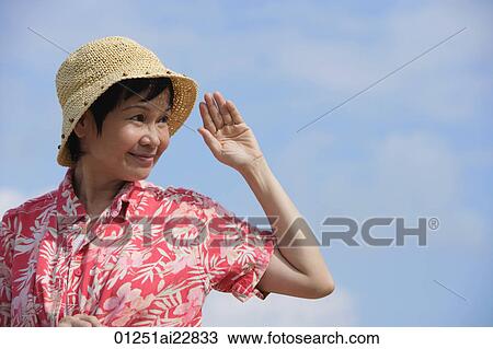Stock Image - Woman at the beach, looking into distance. Fotosearch