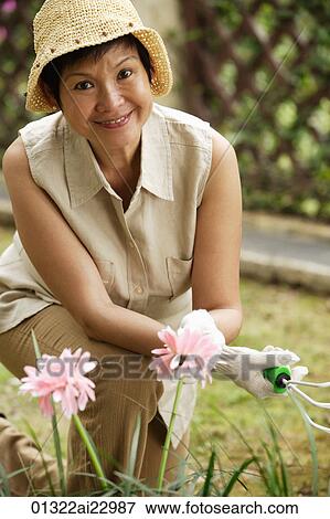 Woman doing gardening while smiling at camera View Large Photo Image Stock Photo - Woman doing gardening while smiling at camera. Fotosearch