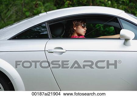 Picture - Woman driving sports car, wearing sunglasses. Fotosearch