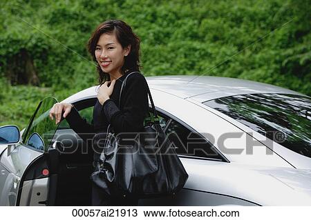 Woman getting into car, smiling at camera View Large Photo Image Stock Image - Woman getting into car, smiling at camera. Fotosearch