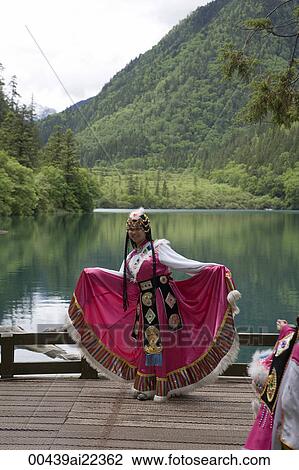 Stock Image - Woman in ethnic costume of Tibet, Xiongmaohai (Panda lake), Jiuzhaigou scenic Area, Wuhang, China. Fotosearch