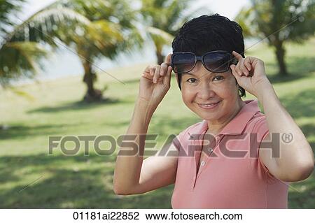 Woman in park smiling at camera View Large Photo Image Stock Image - Woman in park smiling at camera. Fotosearch