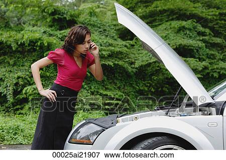 Woman on mobile phone while checking engine of car, hood up, side of road View Large Photo Image Stock Photo - Woman on mobile phone while checking engine of car, hood up, side of road. Fotosearch