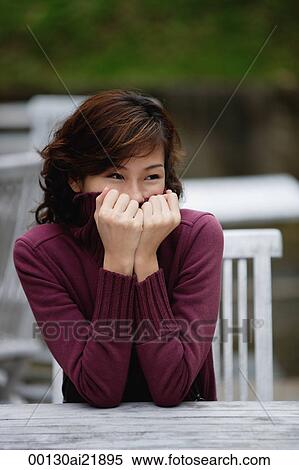 Woman sitting at an outdoor cafe, cover half of face with turtleneck sweater View Large Photo Image Stock Photography - Woman sitting at an outdoor cafe, cover half of face with turtleneck sweater. Fotosearch