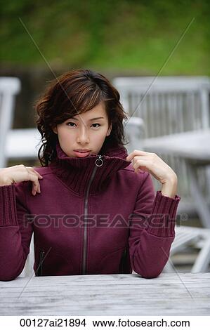 Woman sitting at an outdoor cafe wearing sweater View Large Photo Image Picture - Woman sitting at an outdoor cafe wearing sweater. Fotosearch