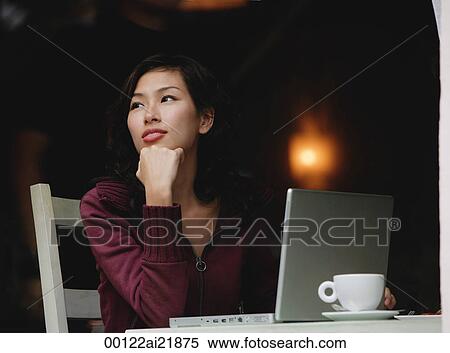 Woman sitting in cafe working on laptop, looking away View Large Photo Image Stock Photography - Woman sitting in cafe working on laptop, looking away. Fotosearch