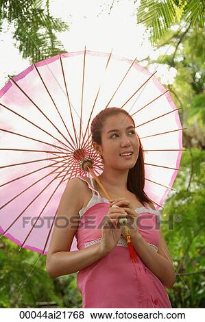 Woman standing under pink umbrella View Large Photo Image Stock Photo - Woman standing under pink umbrella. Fotosearch