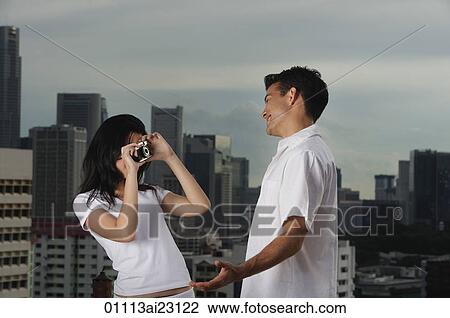 Stock Image - Woman taking picture of man. Fotosearch