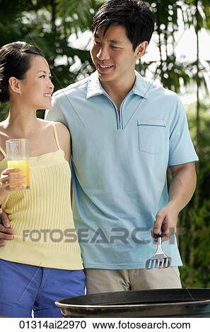 Young couple enjoying a barbeque View Large Photo Image Stock Image - Young couple enjoying a barbeque. Fotosearch