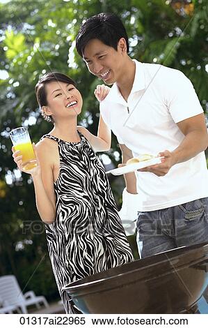 Young couple enjoying a barbeque View Large Photo Image Stock Photography - Young couple enjoying a barbeque. Fotosearch