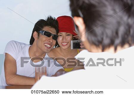 Young couple having their picture taken View Large Photo Image Stock Image - Young couple having their picture taken. Fotosearch