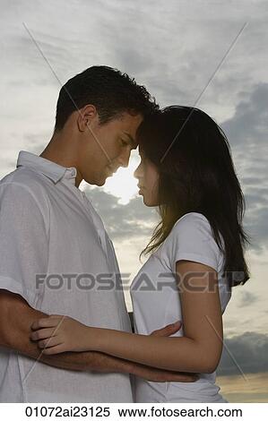 Stock Photography - Young couple hugging and looking at each other. Fotosearch
