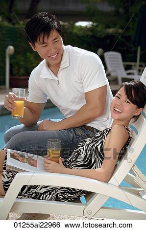 Stock Photograph - Young couple laughing at the pool. Fotosearch