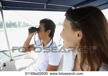 Young couple on yacht, looking into distance View Large Photo Image Stock Image - Young couple on yacht, looking into distance. Fotosearch