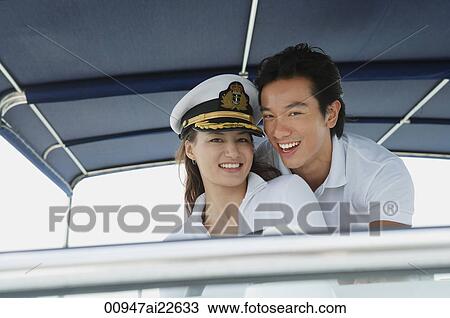 Young couple on yacht, smiling at camera View Large Photo Image Stock Image - Young couple on yacht, smiling at camera. Fotosearch