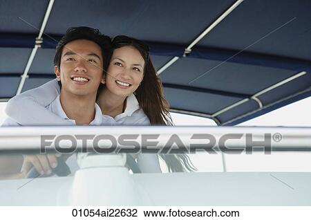 Young couple on yacht, smiling at camera View Large Photo Image Stock Image - Young couple on yacht, smiling at camera. Fotosearch