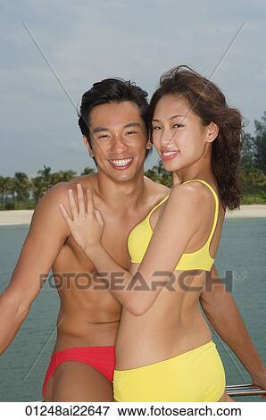 Stock Photo - Young couple on yacht, smiling at camera. Fotosearch