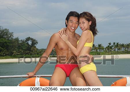 Young couple on yacht, smiling at camera View Large Photo Image Stock Photograph - Young couple on yacht, smiling at camera. Fotosearch